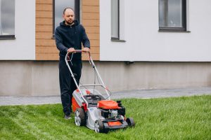 Utah Man cutting grass with lawn mover in the back yard